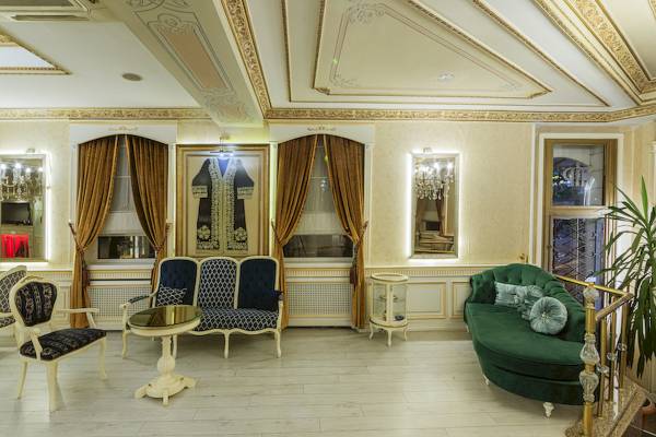 Hotellobby des Ipek Palas mit eleganten Möbeln, goldenen Details und großen Fenstern.