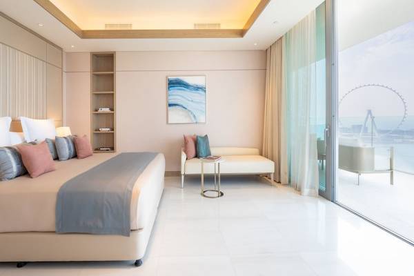 Innenansicht eines Schlafzimmers im FIVE LUXE JBR Hotel mit Bett, Sofa und Panoramafenster.