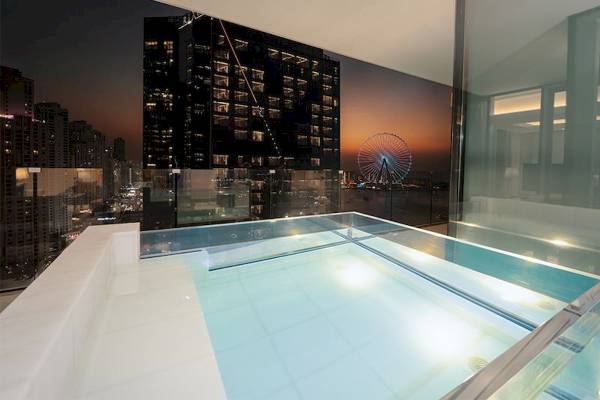 Aussicht auf den Pool im FIVE LUXE JBR mit einer Skyline und einem Riesenrad im Hintergrund.
