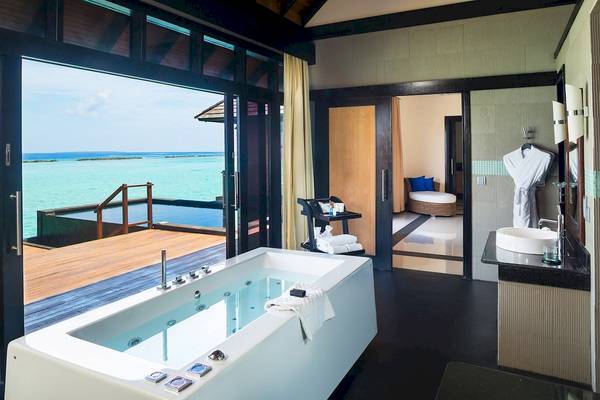Badezimmer mit Meerblick im Sun Siyam Iru Fushi Hotel mit Badewanne und Außenterrasse.