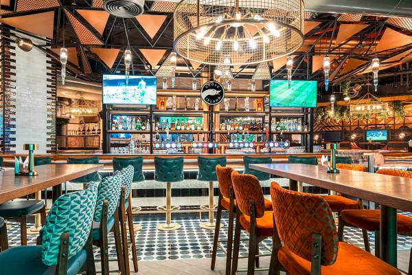 Innenansicht der Bar im FIVE LUXE JBR Hotel mit Barhockern und Tisch.