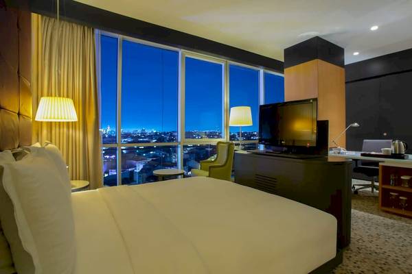 Hotelzimmer von Doubletree by Hilton Istanbul Moda mit Blick auf die Stadt bei Nacht.