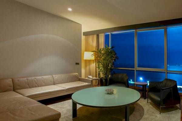 Wohnbereich des Doubletree by Hilton Istanbul Moda Hotels mit Sofa, Tisch und Fenstern.