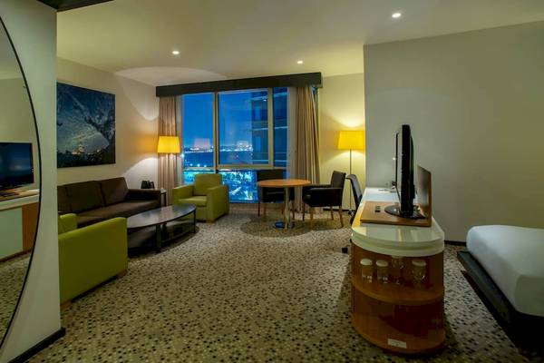 Wohnbereich des Doubletree by Hilton Istanbul Moda Hotels mit Couch, Tischen und Fernsehern.