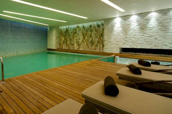 Innenpoolbereich im Doubletree by Hilton Istanbul Moda mit Holzboden und Loungeliegen.