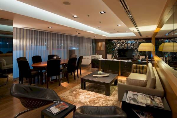 Wohnzimmer im Doubletree by Hilton Istanbul Moda Hotel mit Tisch, Stühlen und Sofas.