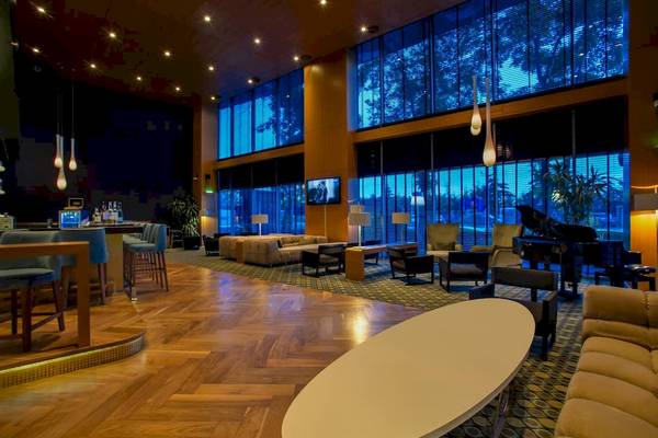 Lobby des Doubletree by Hilton Istanbul Moda mit Klavier, Sofas und großen Fenstern.