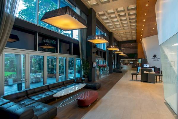 Der elegante Eingangsbereich des Doubletree by Hilton Istanbul Moda Hotels mit modernen Möbeln und Glaswänden.