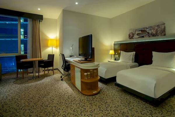Doppelzimmer im Doubletree by Hilton Istanbul Moda mit zwei Betten, Schreibtisch und Fernseher.