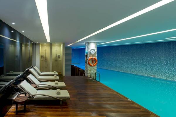 Innenpoolbereich im Doubletree by Hilton Istanbul Moda mit Liegen und blauen Wänden.