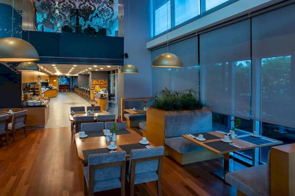 Innenansicht des Restaurants des Doubletree by Hilton Istanbul Moda mit Holzboden, Tisch und Stühlen.