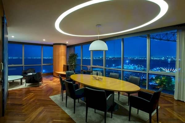 Speisebereich im Doubletree by Hilton Istanbul Moda mit ovalem Tisch und Aussicht auf die Stadt.