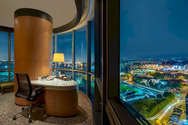 Blick auf die Suite im Doubletree by Hilton Istanbul Moda mit Schreibtisch und Blick auf die Stadt.