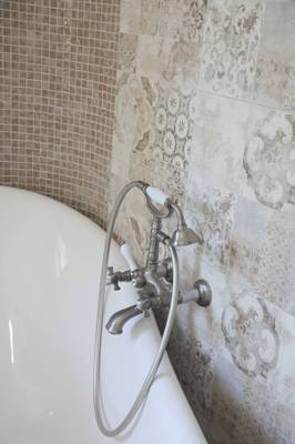 Ein Badezimmer mit einer weißen Badewanne und modernen Armaturen.