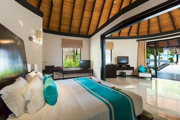 Hotelzimmer im Sun Siyam Iru Fushi mit Blick auf den Ozean und moderne Einrichtung.
