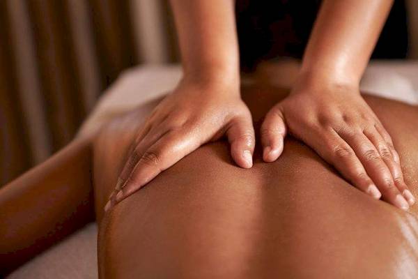 Massage im Hotel La Lagune mit Händen auf dem Rücken einer Person.