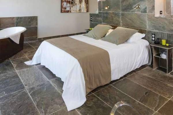 Schlafzimmer im Hotel La Lagune mit einem großen Bett und Badewanne