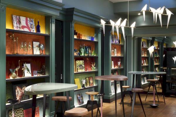 Innenbereich des Leon's Place Hotels mit Tisch, Stühlen, Regalen und Dekoartikeln