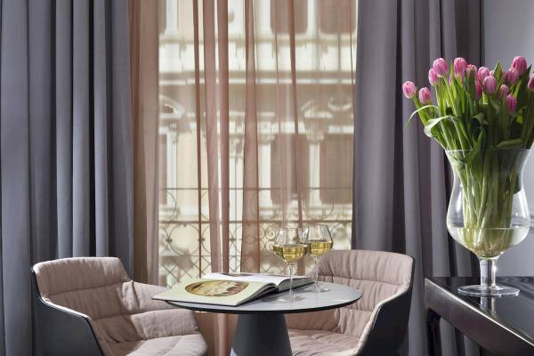 Zimmer im Leon's Place Hotel mit Tisch, Blumenvase und zwei Weingläsern.