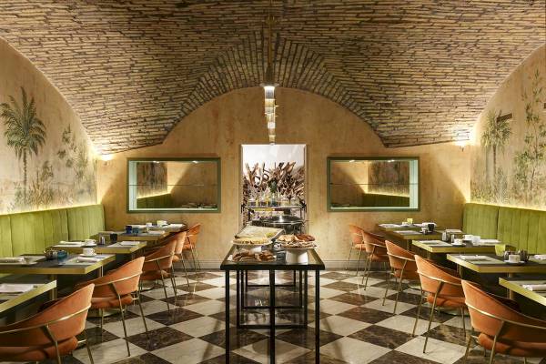 Innenbereich des Restaurants Leon's Place mit gemustertem Boden und runden Tischen.