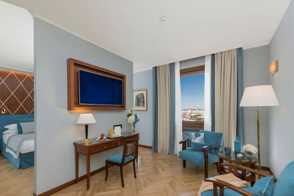 Innenansicht eines Zimmers im Bettoja Hotel Mediterraneo mit Schreibtisch, Fernseher und Fenster mit Stadtblick.