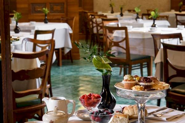 Frühstückstisch im Bettoja Hotel Mediterraneo mit Gebäck, Früchten und Kaffee.