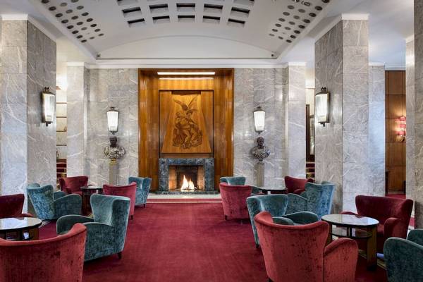 Lobby des Bettoja Hotel Mediterraneo mit rotem Teppich und blauen und roten Stühlen.