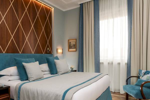 Bettoja Hotel Mediterraneo Zimmer mit Bett, Kissen und Dekor