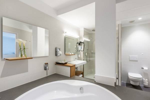 Modernes Badezimmer des ARTIEM Audax Hotels mit Badewanne, Dusche, Toilette und Waschbecken.