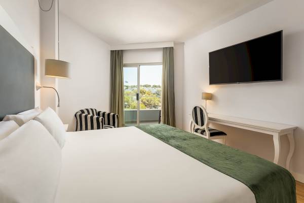 Innenansicht eines Zimmers im ARTIEM Audax Hotel mit einem Bett, Fernseher und Schreibtisch
