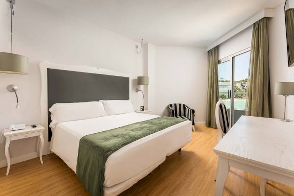 Hotelzimmer im ARTIEM Audax mit großem Bett, Fenstern und Aussicht auf das Meer.