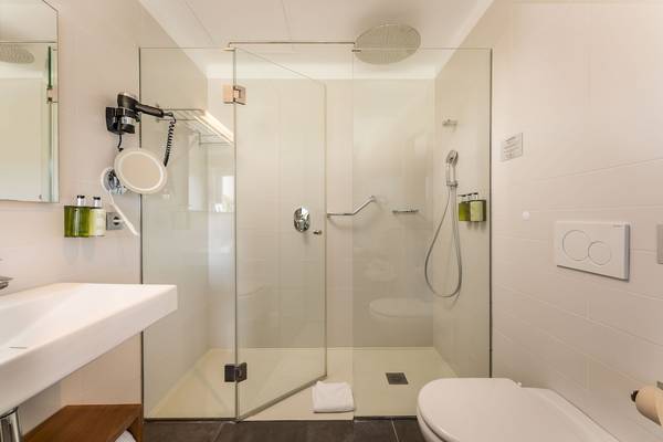 Badezimmer des ARTIEM Audax Hotels mit Glasdusche, Toilette und Waschbecken.