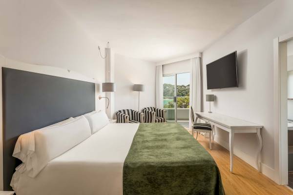 Hotelzimmer des ARTIEM Audax mit einem Bett, Schreibtisch und Aussicht auf den Außenbereich.