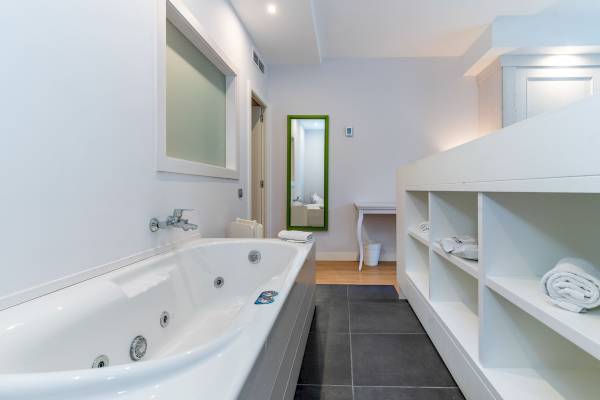 Badezimmer im ARTIEM Audax Hotel mit Badewanne und Regalen
