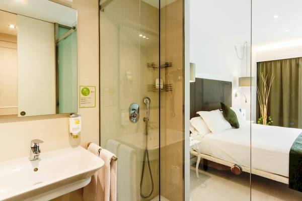 Badezimmer des ARTIEM Audax Hotels mit Glasdusche, Waschbecken und Spiegel.