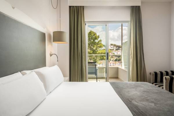 Schlafzimmer im ARTIEM Audax Hotel mit Bett, Kissen und Balkon mit Aussicht