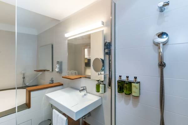 Badezimmer im ARTIEM Audax Hotel mit Badewanne, Waschbecken und Duschkopf.