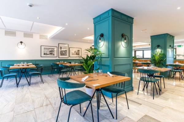 Innenansicht des Restaurants im ARTIEM Audax Hotel mit blauen Stühlen und Tischen.