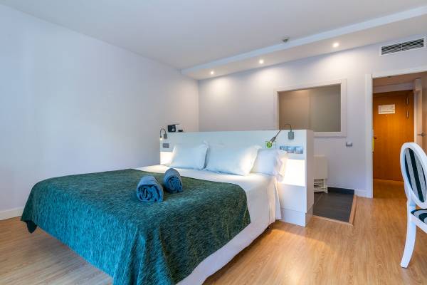 ARTIEM Audax Hotelzimmer mit Bett, Kissen, Decken und Holzboden