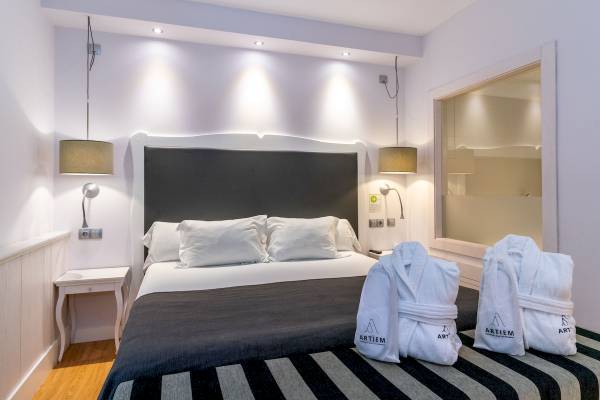 ARTIEM Audax Hotelzimmer mit Bett und weißen Bademänteln