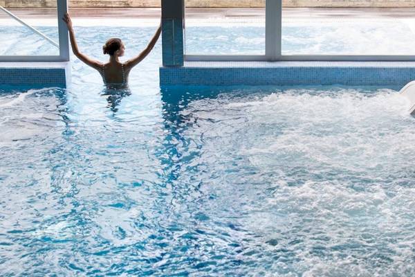 Eine Frau schwimmt im Schwimmbad des ARTIEM Audax Hotels.