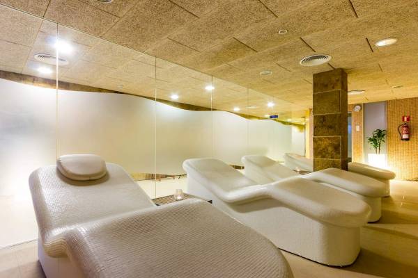 Behandlungsraum im ARTIEM Audax Hotel Spa mit weißen Liegen und Glaswänden.