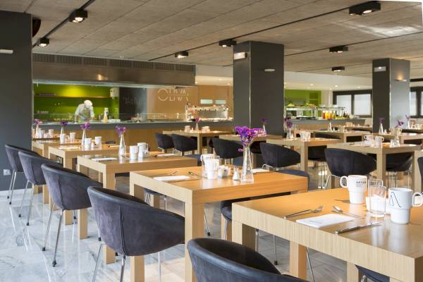 Frühstücksraum im ARTIEM Audax Hotel mit gedeckten Tischen und Stühle.