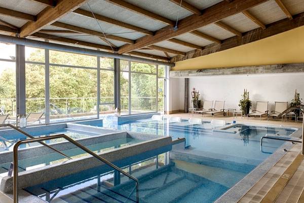 Innenpool im ARTIEM Audax Hotel mit Lounge-Sesseln und großen Fenstern.