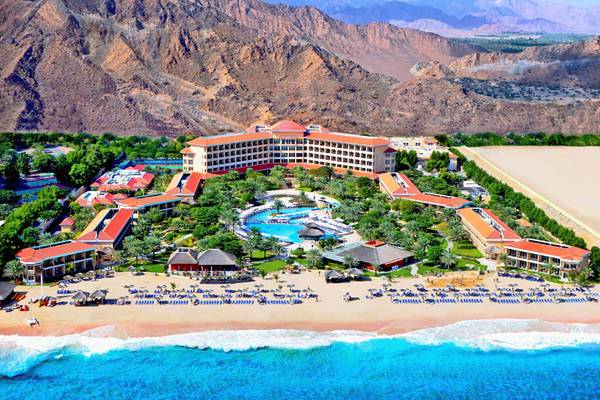 Luftaufnahme des Fujairah Rotana Resort & Spa mit Pool und Berg im Hintergrund