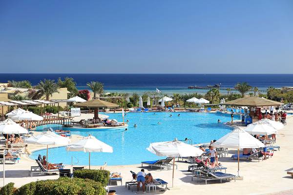 Außenbereich des Drei Ecken Fayrouz Plaza Strand Resorts mit großem Pool und Sonnenliegen.