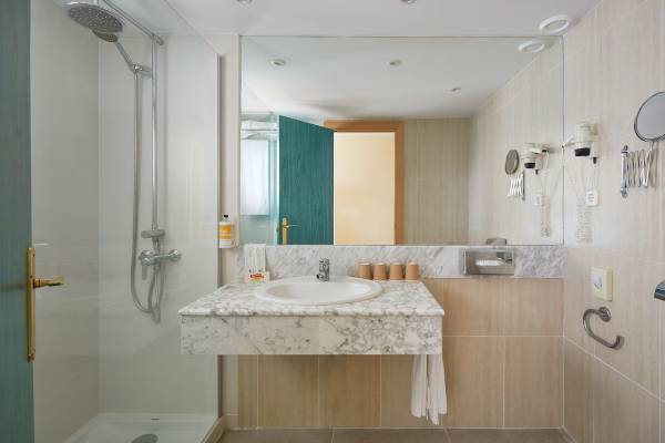 Badezimmer mit Dusche und Spiegel im Sol Milanos Pinguinos Hotel
