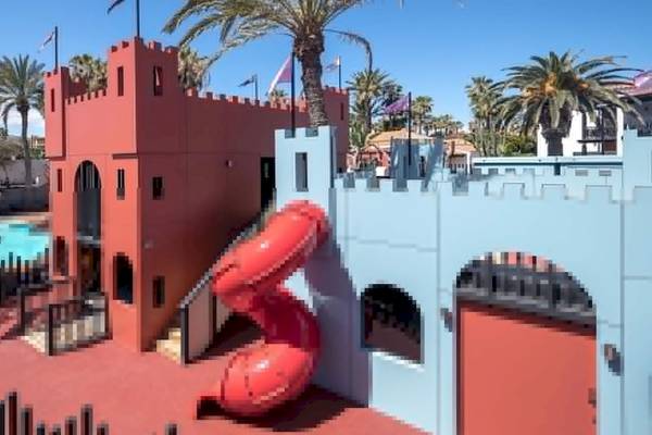Spielplatz im Barcelo Fuerteventura Castillo Hotel mit rotem Rutschenturm und blauem Burgeingang.