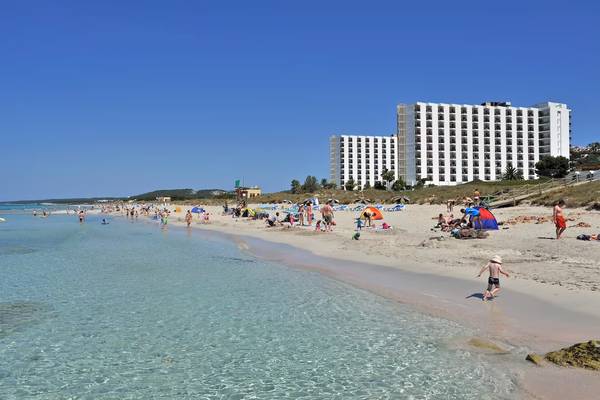 Strand mit vielen Menschen und dem Sol Milanos Pinguinos Hotel im Hintergrund