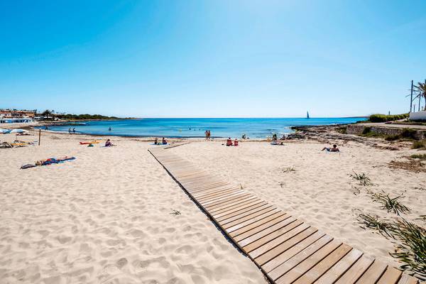 Strand mit hölzernem Steg und vielen Sonnenbadenden am Punta Prima Resort & Spa